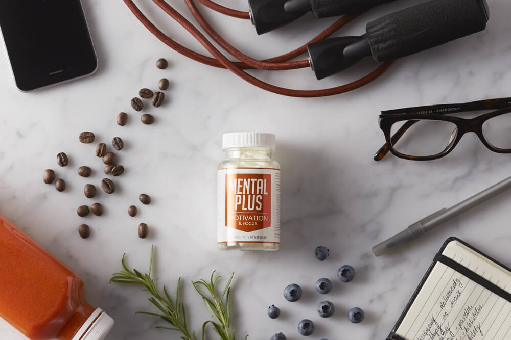 photo of Blex Mental plus in composition with glasse notepad and a glass on a marble background top shot