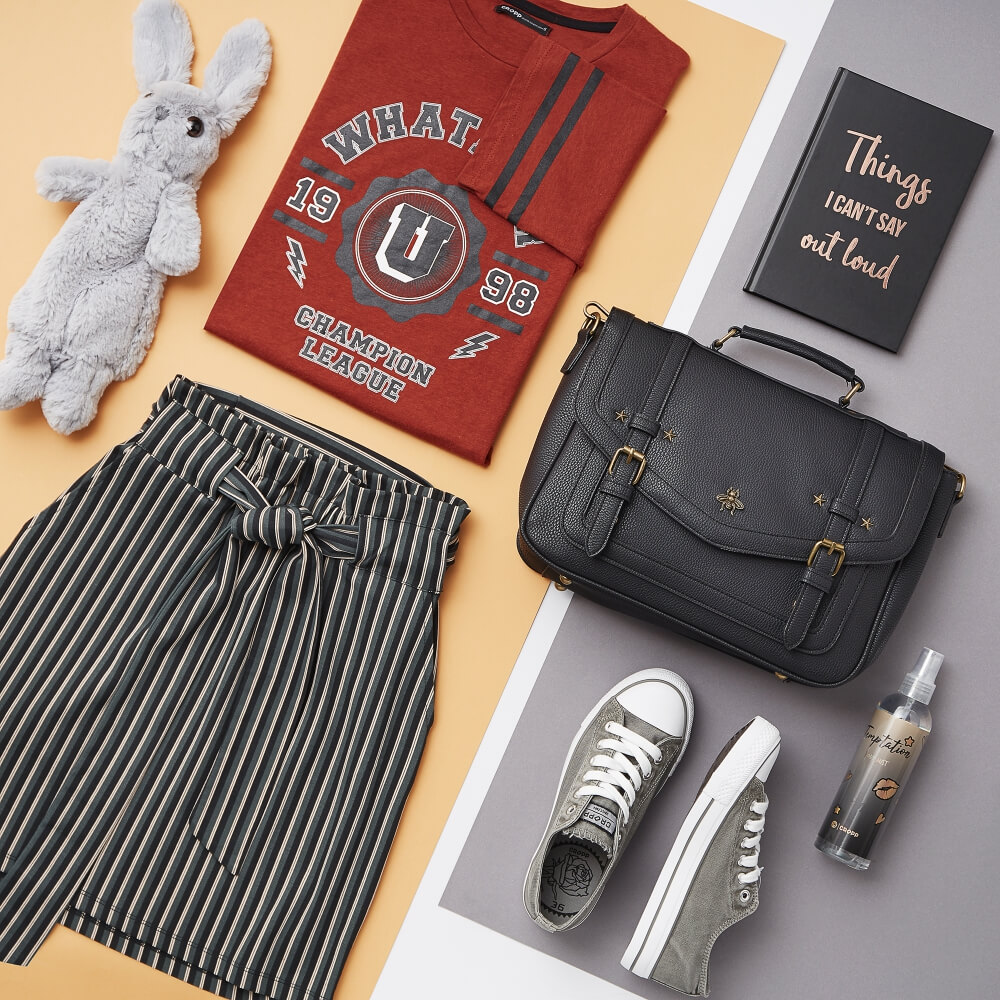 top shot ow woman's Cropp clothing ina creative arrangement on a white grey and yellow background