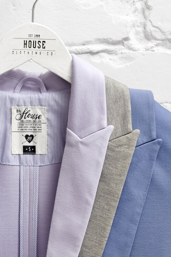 creative commercial photo of House brand Coat hanging on a branded hanger