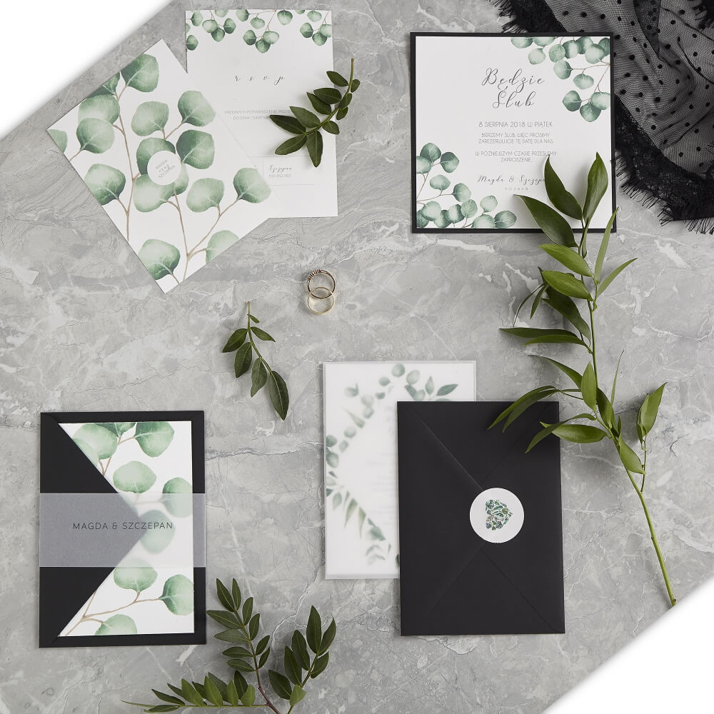 flat lay type photo showing an arrangement of different  products from Biały kot paced among twigs and wedding rings on a white marble