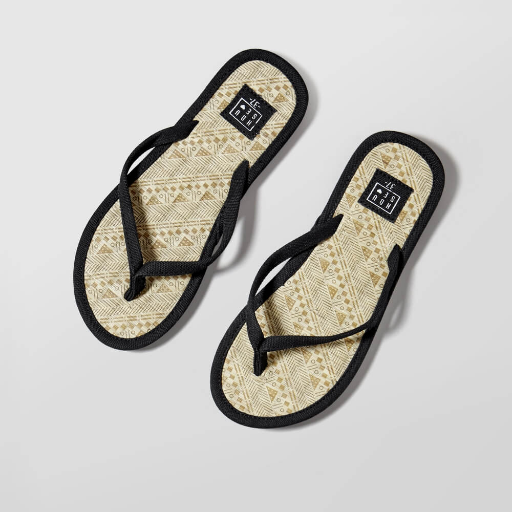 flat lay photo of a pair of House brand flip-flops on a grey background