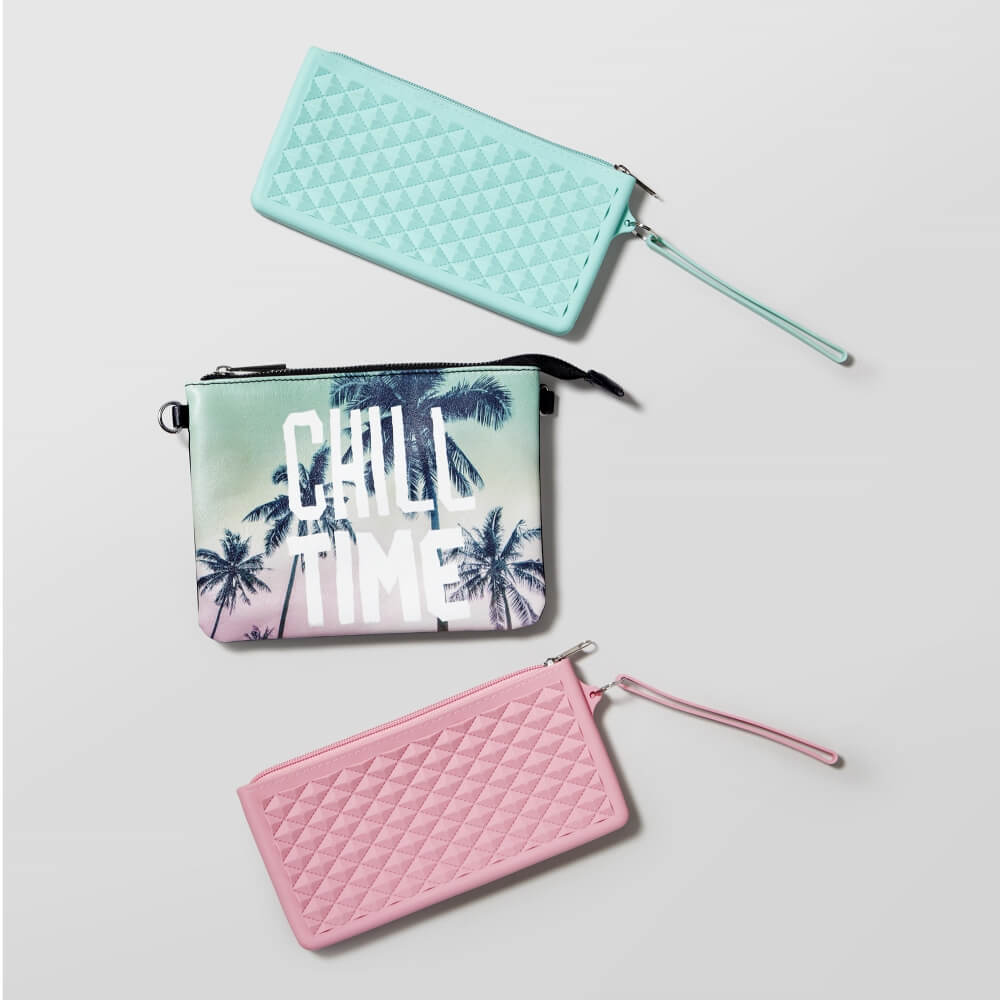 photo of three bags, two colored, one with graphic material on a gray background