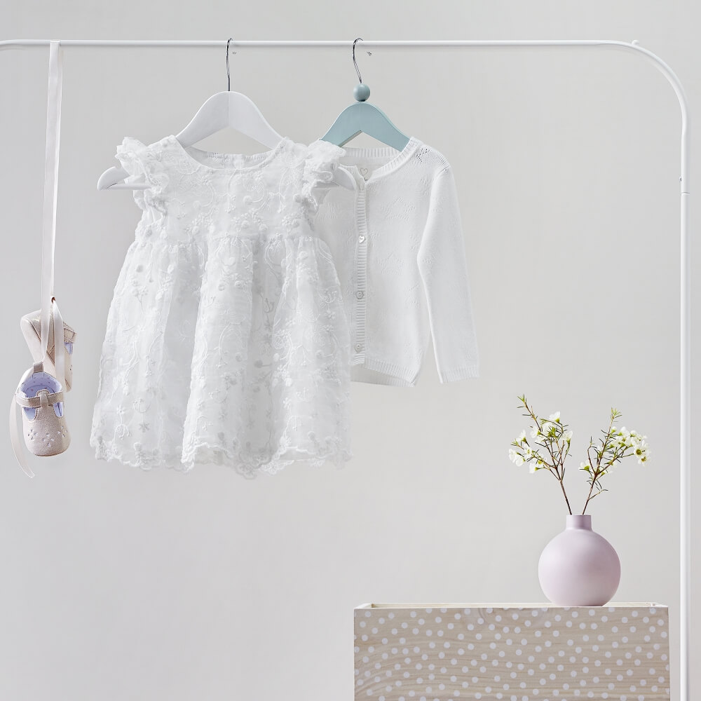 kreatywne zdjęcie ubrań dziecięcych Reserved Kids zawieszonych na wieszaku w jasnej kompozycji