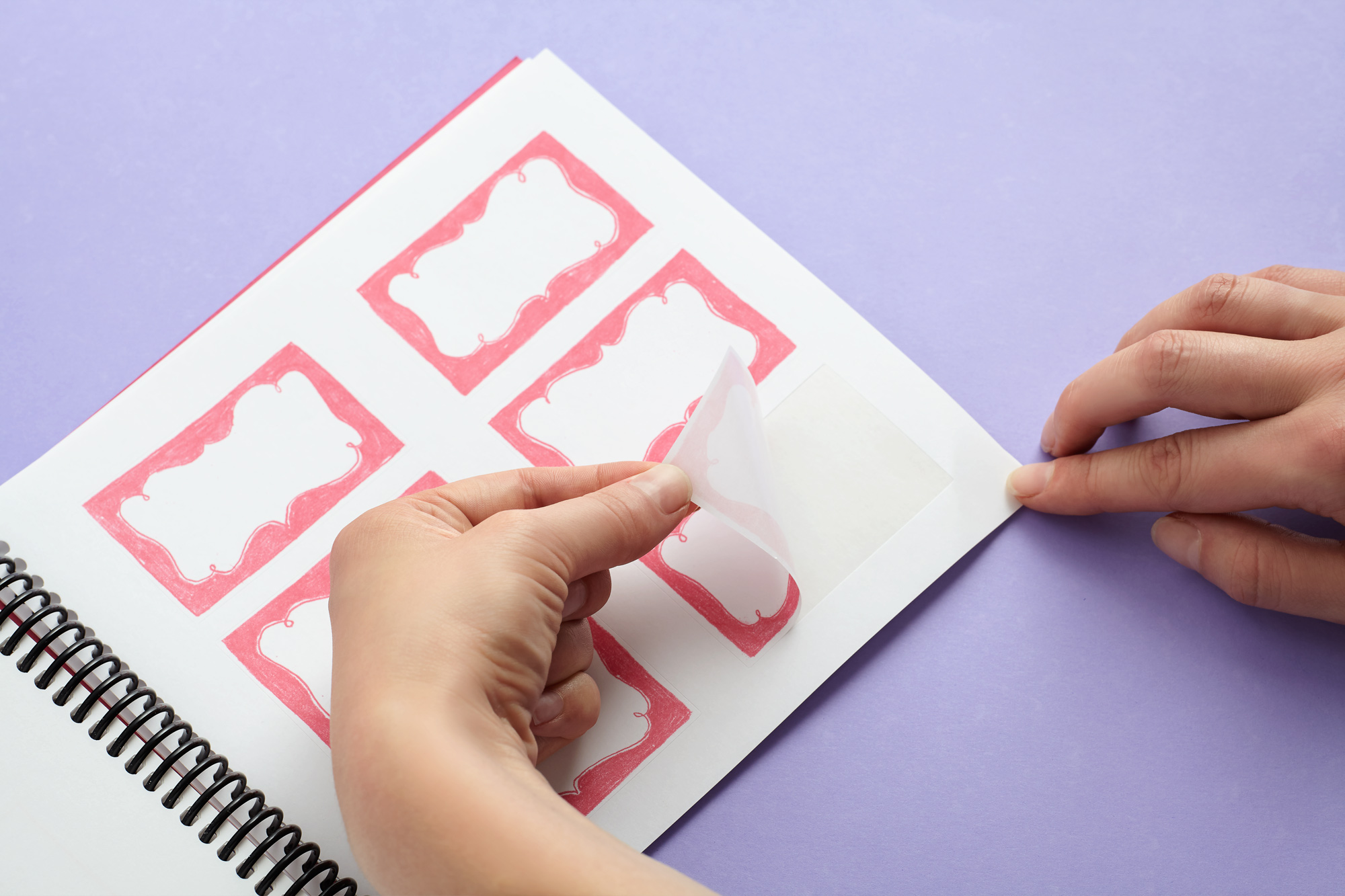 photo showing hand peeling off one of the stickers from inside the book