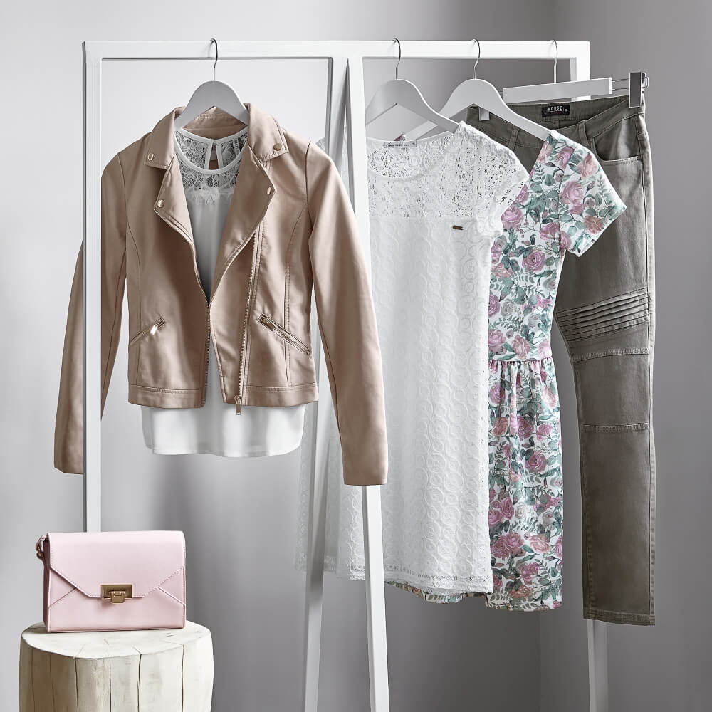 Advertising photo of House clothing on hangers with standing purse aside 