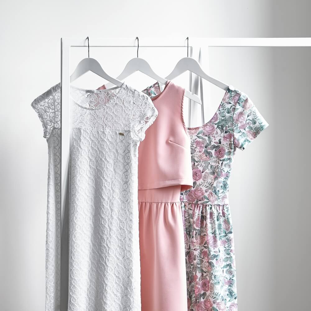 arrangement of three dresses on hangers