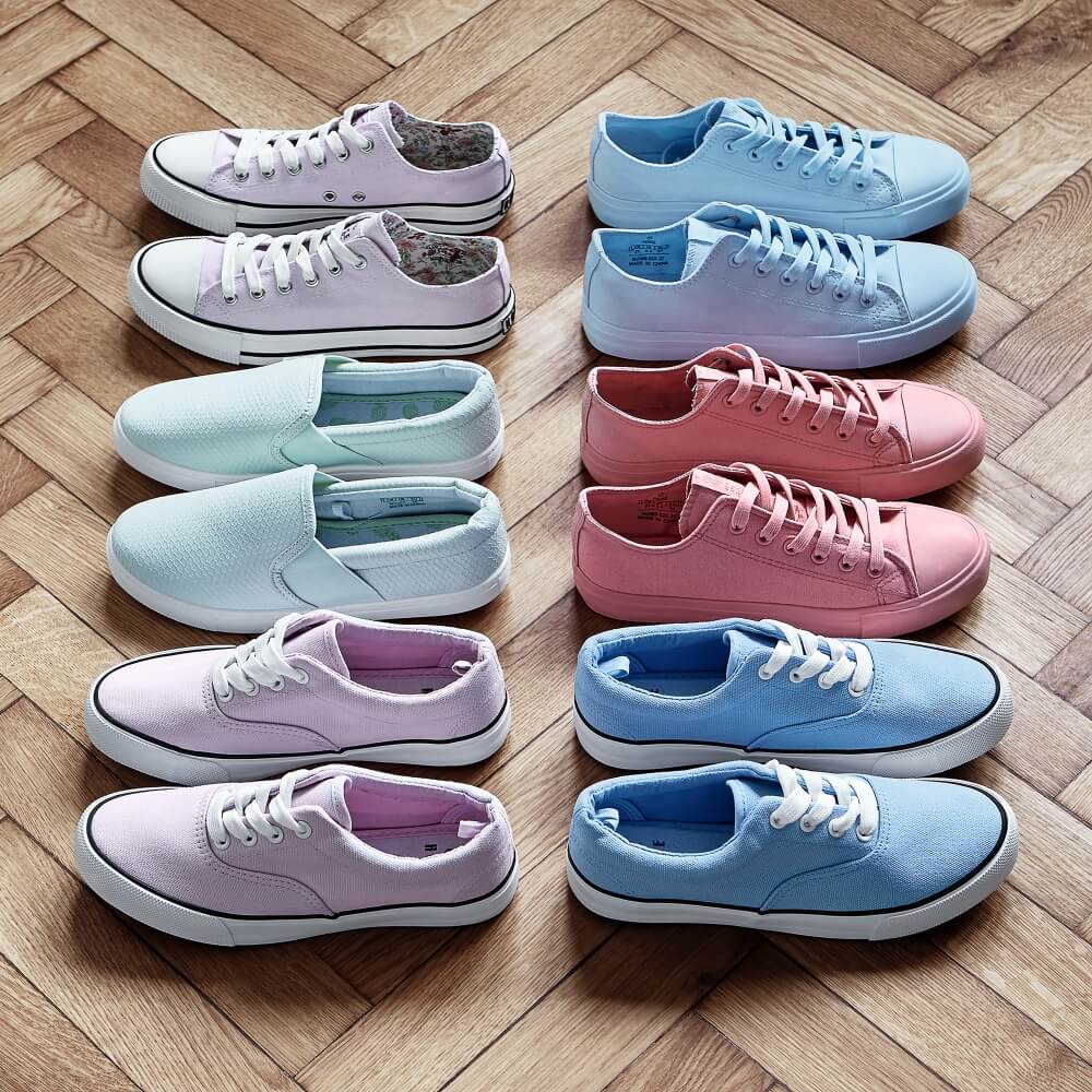 still life photo of six pairs of shoes in different colors arranged on parquet